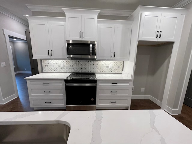 kitchen with light stone countertops, white cabinetry, and stainless steel appliances