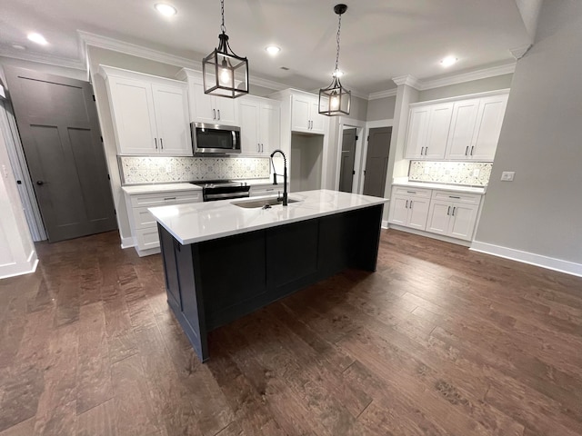 kitchen featuring appliances with stainless steel finishes, white cabinetry, a kitchen island with sink, and sink