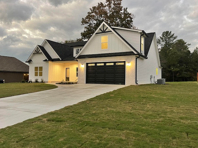 view of front facade with a garage, a front lawn, and central air condition unit