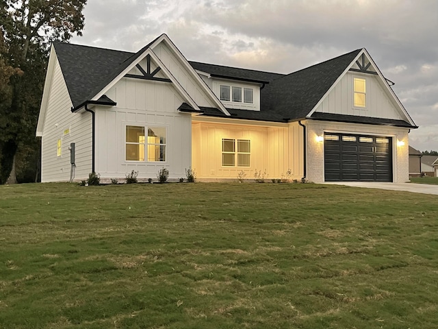 modern inspired farmhouse featuring a garage and a front lawn