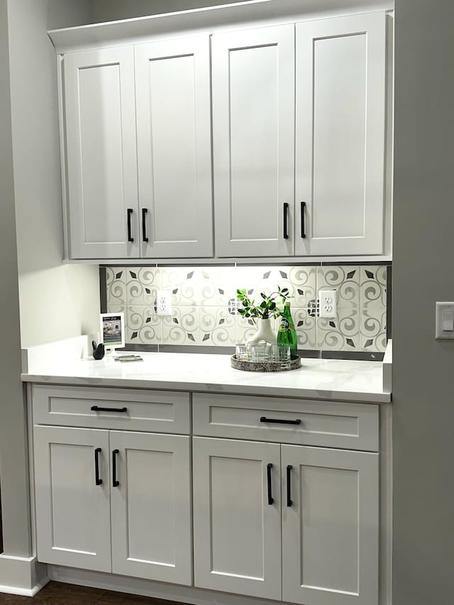 bar with white cabinetry and decorative backsplash