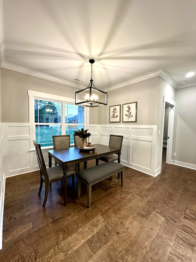 dining space featuring ornamental molding, dark wood-type flooring, and a notable chandelier