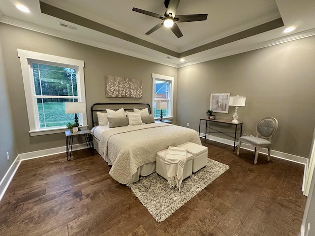 bedroom featuring ceiling fan, dark hardwood / wood-style flooring, ornamental molding, and a tray ceiling