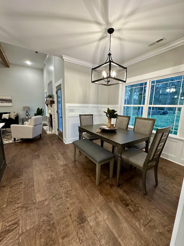 dining room with dark hardwood / wood-style flooring, ornamental molding, and a notable chandelier