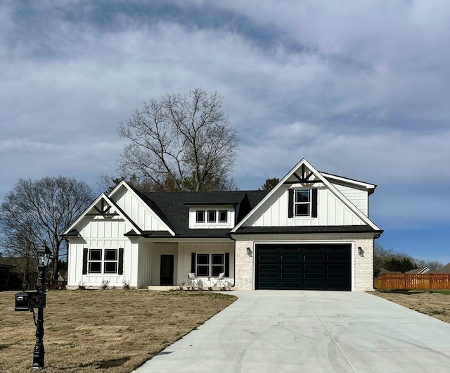 modern farmhouse featuring driveway, brick siding, board and batten siding, and fence