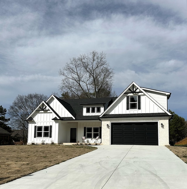 modern farmhouse style home with driveway, roof with shingles, board and batten siding, and a front yard