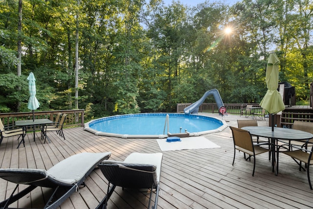 view of swimming pool with a wooden deck and a water slide