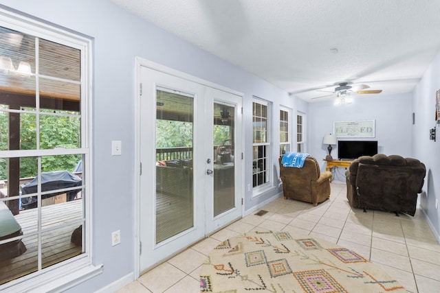 tiled living room with plenty of natural light, ceiling fan, and a textured ceiling