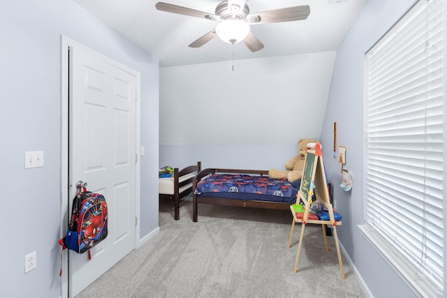 carpeted bedroom with ceiling fan and vaulted ceiling