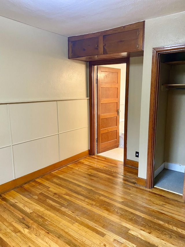 unfurnished bedroom with light hardwood / wood-style floors and a closet