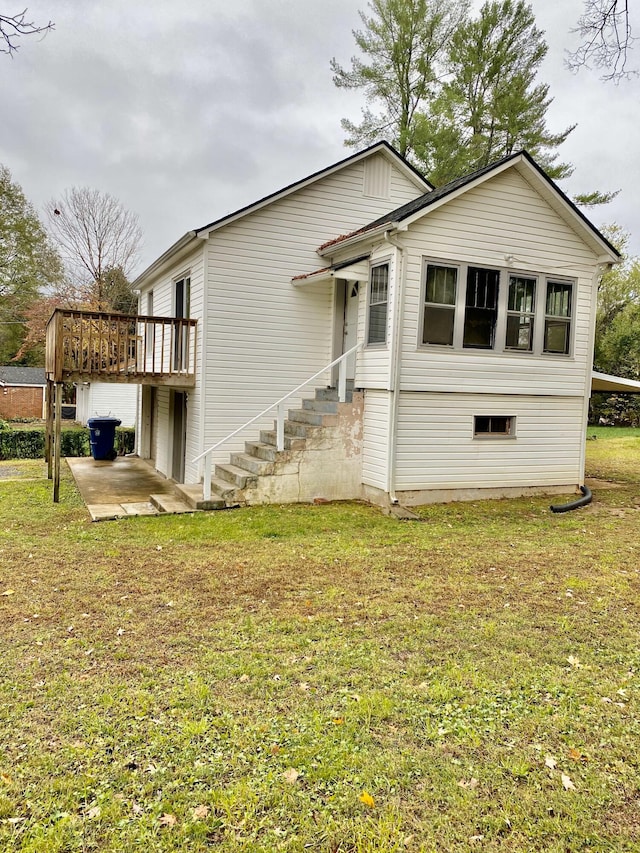 exterior space featuring a lawn, a patio area, and a wooden deck