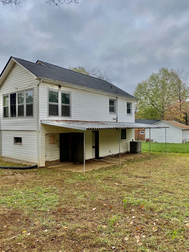 back of property featuring a lawn and central AC