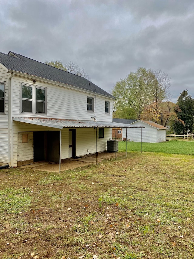 back of house with a yard and central AC