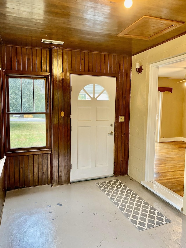 foyer entrance with a wealth of natural light, wooden ceiling, and wood walls