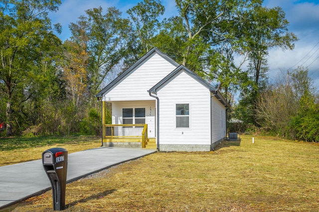 view of home's exterior featuring central AC unit, covered porch, and a yard