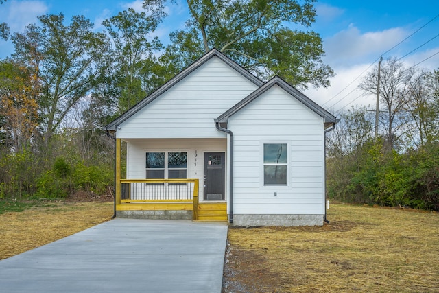 bungalow-style house featuring covered porch and a front yard