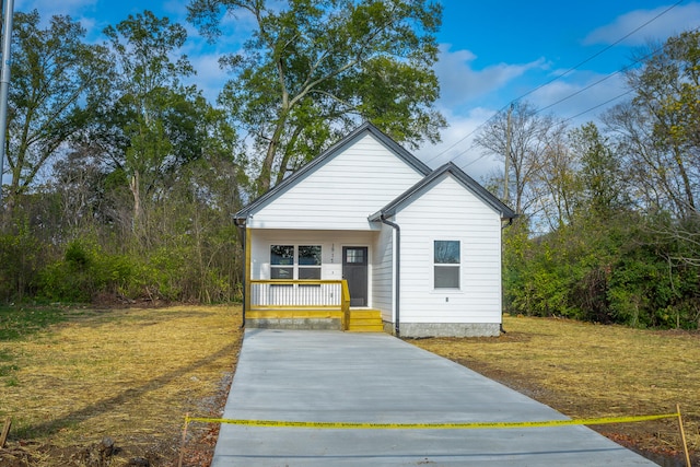 view of front of property featuring covered porch and a front yard