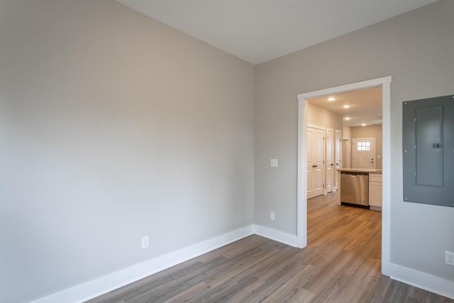 empty room featuring electric panel and light hardwood / wood-style floors