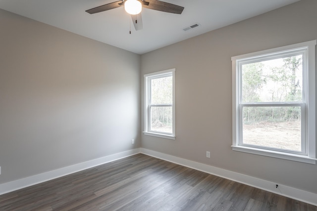 spare room featuring ceiling fan, plenty of natural light, and dark wood-type flooring