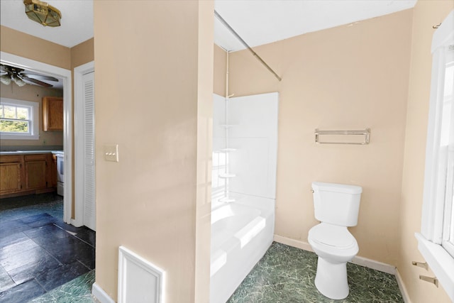 bathroom featuring bathing tub / shower combination, ceiling fan, and toilet