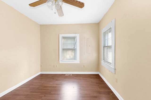 empty room with dark hardwood / wood-style floors and ceiling fan