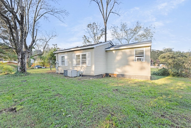 rear view of house featuring central AC and a yard