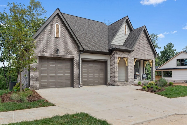 view of front of property featuring covered porch, a garage, and central air condition unit