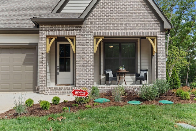 view of exterior entry with a porch and a garage