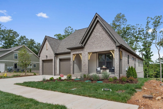 view of front facade featuring covered porch, a garage, and a front lawn