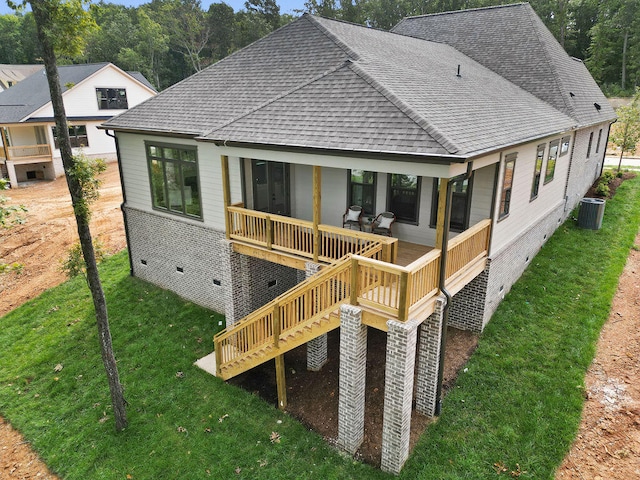 rear view of house featuring a yard, cooling unit, and a wooden deck