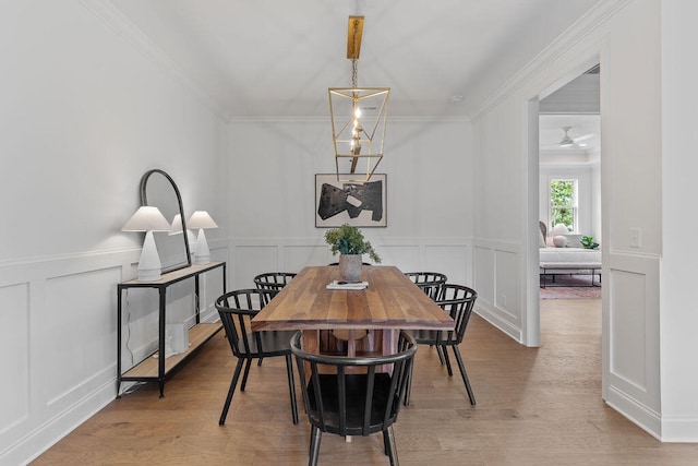 dining area featuring ceiling fan, light wood-type flooring, and crown molding