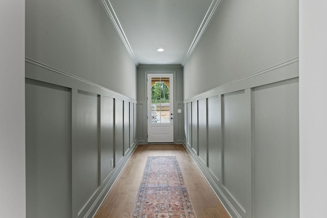 doorway to outside with light hardwood / wood-style flooring and ornamental molding