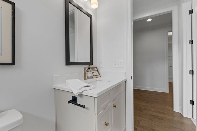 bathroom with vanity, hardwood / wood-style flooring, toilet, and crown molding