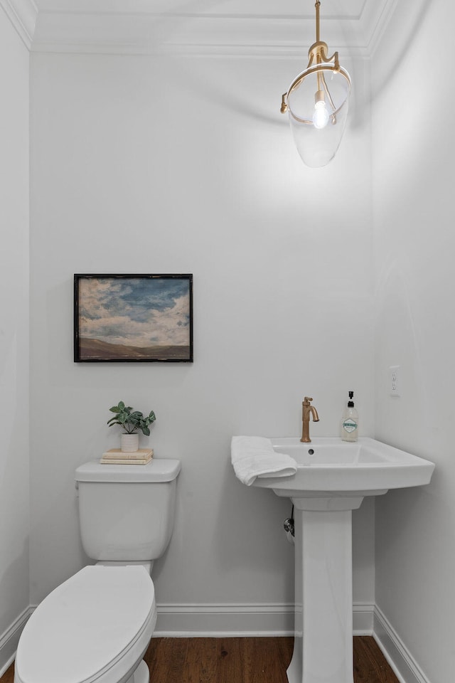 bathroom featuring hardwood / wood-style flooring, toilet, and crown molding