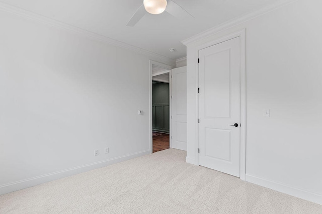 carpeted empty room with ceiling fan and ornamental molding