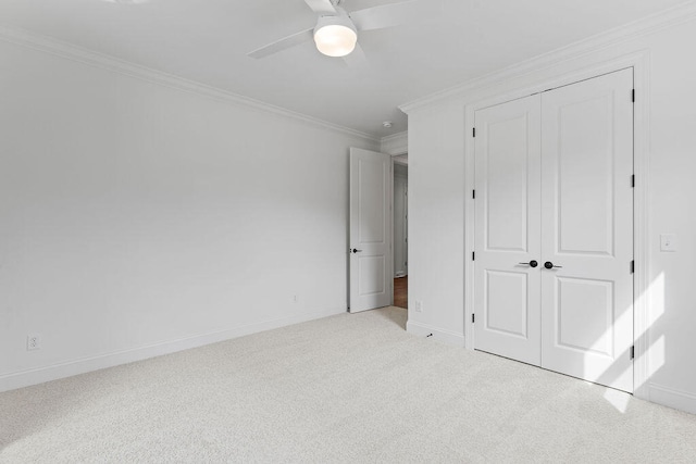 unfurnished bedroom with crown molding, ceiling fan, a closet, and light carpet