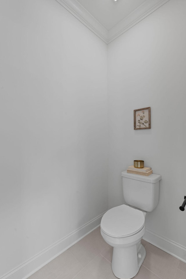 bathroom with tile patterned flooring, toilet, and crown molding