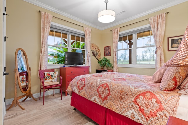 bedroom featuring light hardwood / wood-style floors, ornamental molding, and multiple windows