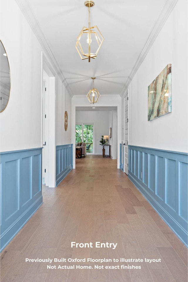 hall with a chandelier, crown molding, and wood-type flooring