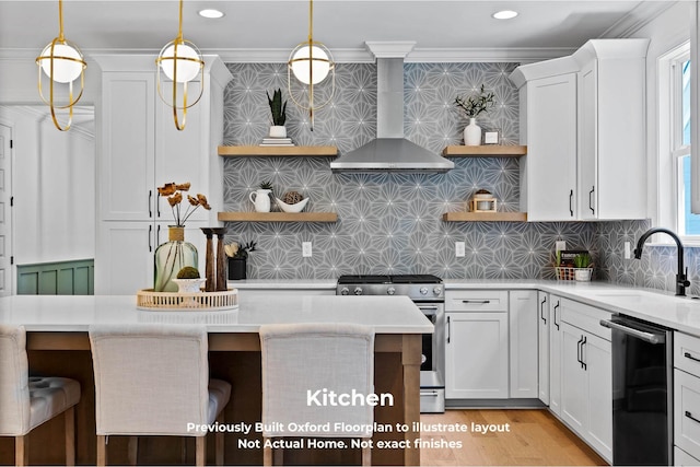 kitchen with white cabinetry, wall chimney exhaust hood, a breakfast bar area, decorative backsplash, and appliances with stainless steel finishes