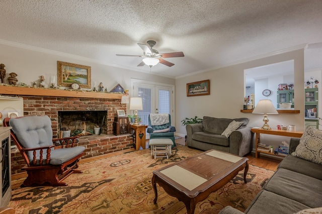 living room featuring ceiling fan, crown molding, a textured ceiling, a fireplace, and hardwood / wood-style flooring