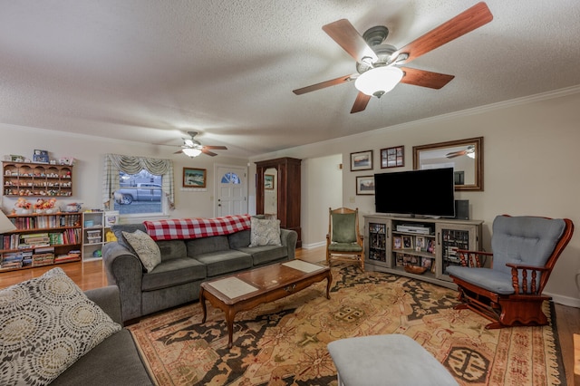 living room featuring hardwood / wood-style floors, ceiling fan, and a textured ceiling