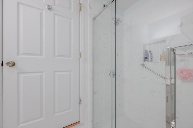 bathroom featuring a shower with door