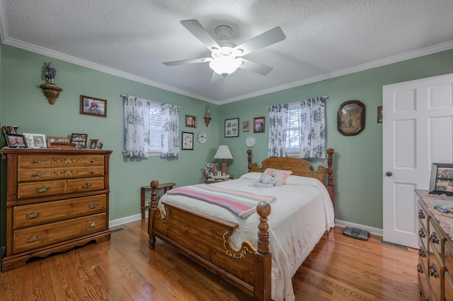 bedroom featuring a textured ceiling, ceiling fan, crown molding, and light hardwood / wood-style flooring