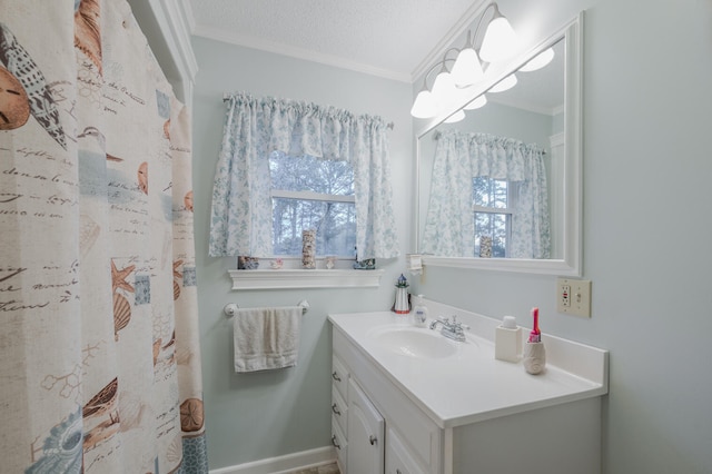 bathroom with vanity, a textured ceiling, a wealth of natural light, and crown molding