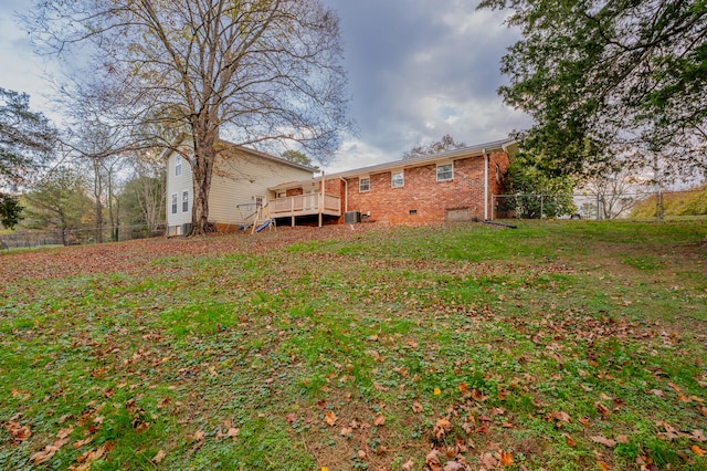 back of house featuring a lawn and a wooden deck