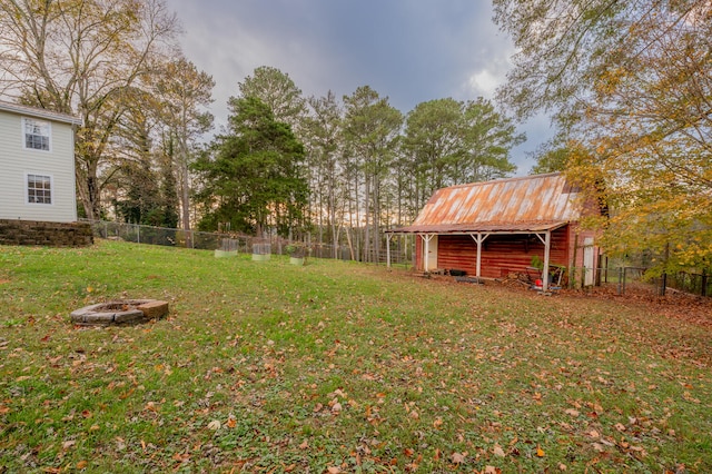 view of yard featuring an outbuilding and an outdoor fire pit