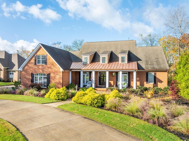 new england style home featuring covered porch