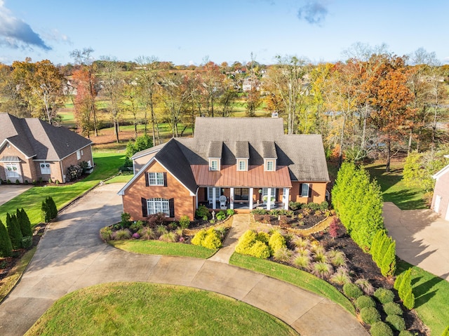 cape cod-style house with a front yard