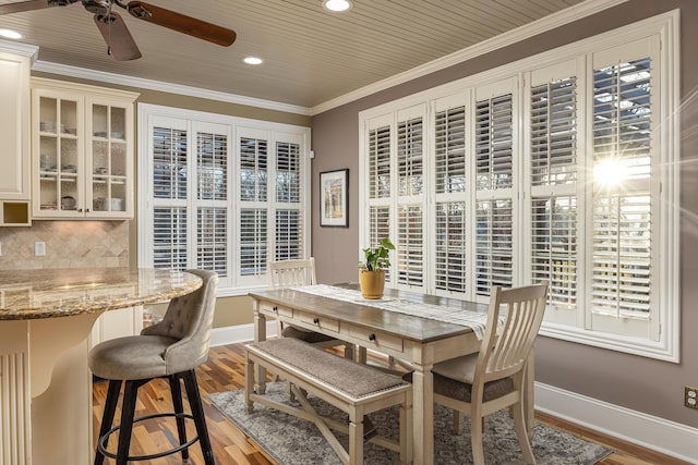 dining space featuring wood-type flooring, ceiling fan, and ornamental molding